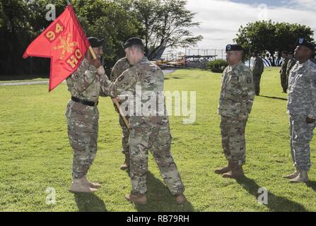 JOINT BASE Pearl Harbor - HICKAM, Hawaii - Kapitän Jeffrey Scott, ein Air Defense Artillery Officer und ausgehende Commander mit Sitz und Hauptverwaltung Batterie, 94th Army Air und Raketenabwehr Befehl, U.S. Army Pacific, leitet die Steuereinheit guidon nach Brig. Gen. Sean A. Gainey, Kommandierender General des 94. AAMDC, Dez. 16, 2016, während die Batterie wechseln des Befehls Zeremonie am Joint Base Pearl Harbor-Hickam, Hawaii. Die Verabschiedung des Guidon symbolisiert der scheidende Kommandant der Verzicht auf Befehl zu seinem Nachfolger. Stockfoto