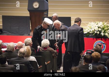 Der Vizepräsident der Vereinigten Staaten Joe Biden hilft Annie Glenn einen Sitz während der Feier des Lebens für Senator John Glenn, jr., an der Ohio State University, Columbus, Ohio, Dez. 17, 2016. In geflogen 149 Einsätze im Zweiten Weltkrieg und im Koreakrieg, Glenn der erste Mensch wurde die Erde im Jahr 1962. Nach seinem Ausscheiden aus dem Raumfahrtprogramm, Glenn war der US-Senat 1974 gewählt Der Zustand von Ohio zu vertreten. Stockfoto