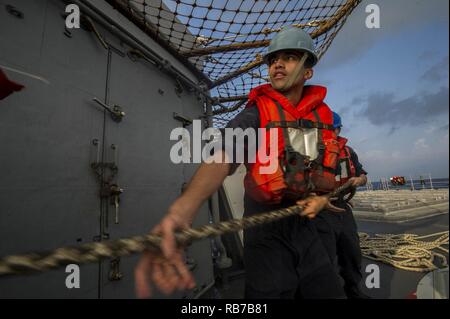 Roten Meer (31. 1, 2016) Petty Officer 3rd Class Francisco Quijano, von Fresno, Kalifornien, wuchtet eine Zeile während einer Auffüllung auf See an Bord der geführte-missile Cruiser USS San Jacinto (CG56). San Jacinto, eingesetzt als Teil der Eisenhower Carrier Strike Group, unterstützt Maritime Security Operations und Theater Sicherheit Zusammenarbeit in den USA 5 Flotte Bereich der Operationen. Stockfoto