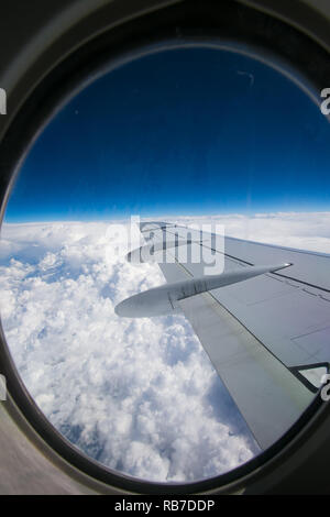 Blick aus dem Fenster des Flugzeugs auf dem Flügel und Motoren von der Fokker 100-Modell mit blauem Himmel und weißen Wolken. Bei schönem Wetter Stockfoto