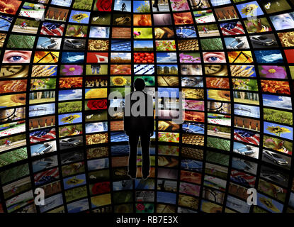 Sphärische Zimmer mit einer Mauer von Fernsehen und ein Mann stand auf einer reflektierenden Boden, es Stockfoto