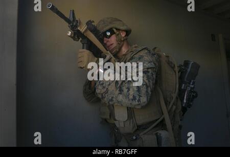 Ein Marine bietet Sicherheit von einem Gebäude als Mitsoldaten im übrigen Gebäude klar während der RAID-evolution von Stahl Ritter 17 bei Marine Corps Base Camp Pendleton, Calif., Dez. 4, 2016. Stahl Ritter ist eine Abteilung ebene Übung entwickelt, um die Kontrolle und Steuerung sowie die Interoperabilität mit den 1St Marine Division, der angrenzenden Einheiten und Naval support Kräfte zu erhöhen. Stockfoto