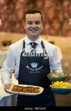 Kellner Holding typisch portugiesischen Gericht Leitão à Bairrada an der Rei dos Leitões Restaurant, Setúbal, Portugal, Europa Stockfoto