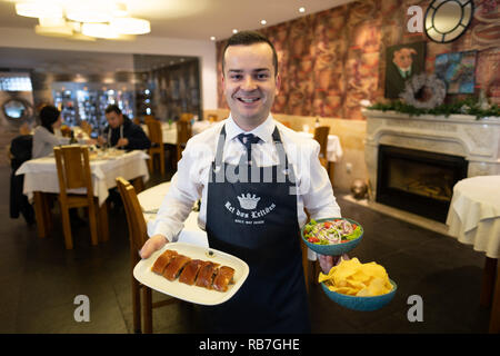 Kellner Holding typisch portugiesischen Gericht Leitão à Bairrada an der Rei dos Leitões Restaurant, Setúbal, Portugal, Europa Stockfoto