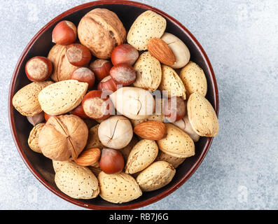 Verschiedene Nüsse in der Schale - Mandeln, Haselnüsse, Pekannüsse, Walnüsse. Gourmet Snack. Gesundes Essen. Selektiver Fokus Stockfoto