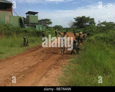 Kampala, Uganda (31. 06, 2016) Task Force Sparta Petty Officer 2nd class Devyn Lopez beauftragt ugandischen Soldaten auf, wie man richtig Abdeckung während demontiert Patrouillen während des Trainings als Teil der Afrikanischen Blindbewerbungen Ausbildung und Unterstützung in Kampala, Uganda, Dez. 6, 2016. 6. US-Flotte mit Sitz in Neapel, Italien, führt das gesamte Spektrum von Gelenk- und Naval operations, oft im Konzert mit Alliierten, Gelenk- und interagency Partnern, um US-amerikanischen nationalen Interessen und die Sicherheit und Stabilität in Europa und Afrika. Stockfoto