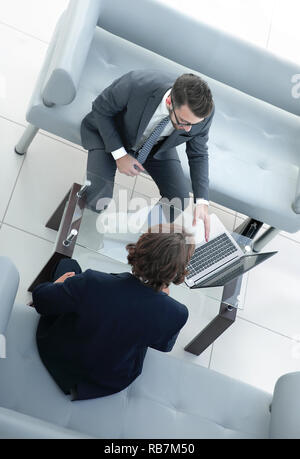 Zwei Geschäftsleute über Aufgaben im Büro sitzen. Stockfoto
