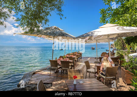 Ohrid, Mazedonien - 1. Juni 2018 - Paar Mittagessen in einer erstaunlichen Szenario mit dem Ohrid-see in einem blauen Himmel Tag in Mazedonien Stockfoto