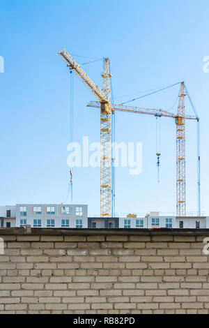 Krane und Gebäude hinter dem Zaun Stockfoto