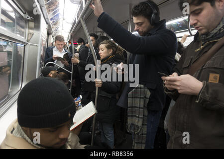 U-Bahn Fahrer gehen von Brooklyn nach Manhattan auf eine F Zug am Morgen. Stockfoto