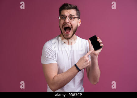 Sie haben Probleme Mann! Portrait von Angry verwirrt aggressiv in schlechte Stimmung Kerl schreien in der Laut-sprecher sein Smartphone bedrohlich, auf rosa Hintergrund isoliert. Stockfoto
