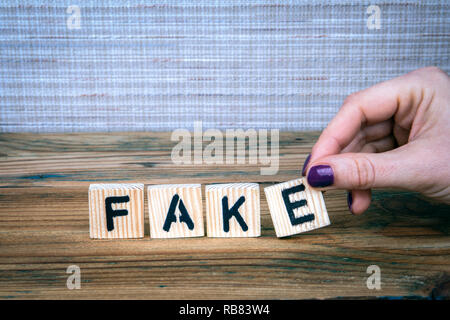 Fake. Holz- Buchstaben auf dem Schreibtisch Stockfoto