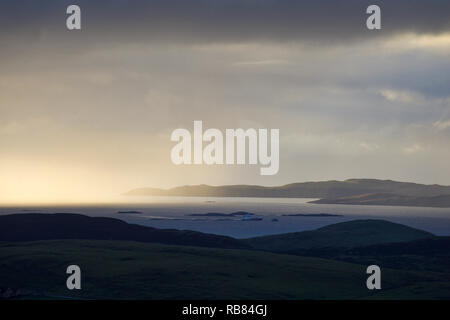 Dunkle Sturmwolken ziehen sich über eine dramatische Shetland-Landschaft – stimmungsvoller Himmel trifft auf zerklüftete Hügel und windgepeitschtes Gelände auf den abgelegenen nördlichen Inseln. Stockfoto