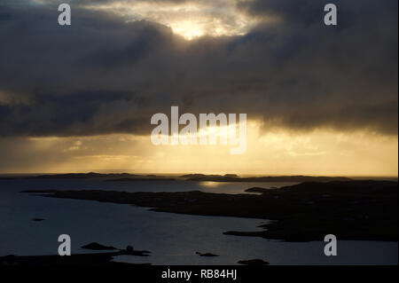Dunkle Sturmwolken ziehen sich über eine dramatische Shetland-Landschaft – stimmungsvoller Himmel trifft auf zerklüftete Hügel und windgepeitschtes Gelände auf den abgelegenen nördlichen Inseln. Stockfoto