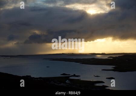 Dunkle Sturmwolken ziehen sich über eine dramatische Shetland-Landschaft – stimmungsvoller Himmel trifft auf zerklüftete Hügel und windgepeitschtes Gelände auf den abgelegenen nördlichen Inseln. Stockfoto
