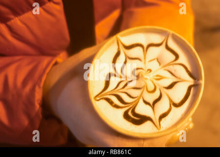 Leckere, frische Morgen Cappuccino mit Blume auf dem Milchschaum gezeichnet, weiße Schokolade Cookies auf der Seite und einen großen Haufen von weißen Tulpen auf t Stockfoto