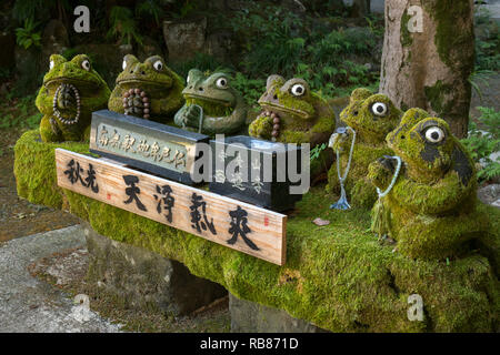 Sasebo, Japan - Oktober 29, 2018: Zeile aus Stein Frösche vor der buddhistischen Anyo-zan Seiren-ji-Tempel in Meganeiwa Park, auf dem Holzbrett ist writ Stockfoto