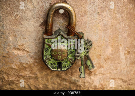 Alte Metall Schloss und zwei Schlüssel auf dem Hintergrund Sandsteinmauer Stockfoto