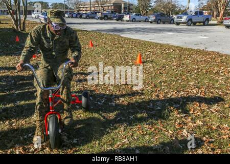 Lance Cpl. Deshawn Flanagan versucht, einen Kurs auf einem Dreirad, während der Nationalen gehinderten Fahren Prävention Monat Veranstaltung im goettge Memorial Field House auf der Marine Corps Base Camp Lejeune, Dez. 9 navigieren. Die Teilnahme an der Veranstaltung war die Wahl des Spielens von Mais Loch, Dreiräder, oder der Absturz Erfahrung Schlitten alle beim Tragen von Impairment goggles, die die Auswirkungen der vom Verstand berauscht werden ändern Stoffe nachahmen. Die Veranstaltung wurde moderiert von Marine Corps Community Services, bei der Förderung des Bewusstseins der Risiken im Zusammenhang mit dem Fahren, während sie berauscht, sms oder das Fahren mit einem Stockfoto