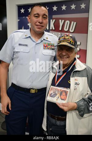 Petty Officer 1st Class Josh Lamborn, ein Yeoman bei Coast Guard Base Honolulu stationiert und heimisch in Santa Ana, Kalifornien, posiert für ein Foto mit Barney Leone, eine Marine Weltkriegveteran und Heimisch in New York City, bevor eine amerikanische Fluggesellschaft Ehre Flug zurück nach Los Angeles am internationalen Flughafen von Honolulu, Dez. 9, 2016. Mehr als 100 Weltkriegveterane, einschließlich Pearl Harbor Überlebenden, in Erinnerung Ereignisse während der gesamten Woche nahmen den Mut und die Opfer derjenigen, die während der dez. 7, 1941 zu Ehren, und in der gesamten pazifischen Theater. Dez. 7, 2016, markierte den 75th Anniv Stockfoto