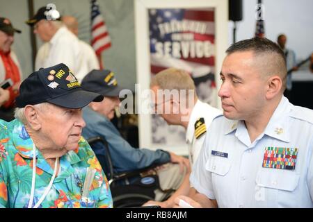 Petty Officer 1st Class Josh Lamborn, ein Yeoman bei Coast Guard Base Honolulu stationiert und heimisch in Santa Ana, Kalifornien, spricht mit ehemaligen Marine Corps Pfc. James Krodel, ein Weltkriegveteran und gebürtige Quitman, Texas, bevor eine amerikanische Fluggesellschaft Ehre Flug zurück nach Los Angeles am internationalen Flughafen von Honolulu, Dez. 9, 2016. Mehr als 100 Weltkriegveterane, einschließlich Pearl Harbor Überlebenden, in Erinnerung Ereignisse während der gesamten Woche nahmen den Mut und die Opfer derjenigen, die während der dez. 7, 1941 zu Ehren, und in der gesamten pazifischen Theater. Dez. 7, 2016, markierte den Stockfoto