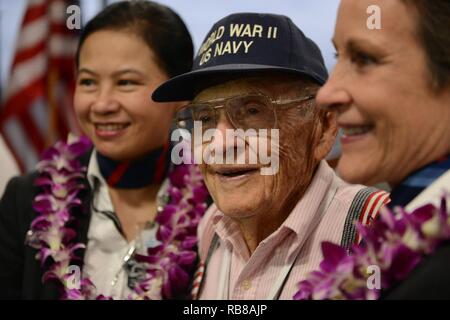 Ehemalige Navy Petty Officer 2nd class Burke Waldron, ein Weltkriegveteran und heimisch in St. George, Utah, lächelt für ein Foto mit zwei American Airlines Flight Attendants, bevor eine Ehre Flug zurück nach Los Angeles am internationalen Flughafen von Honolulu, Dez. 9, 2016. Mehr als 100 Weltkriegveterane, einschließlich Pearl Harbor Überlebenden, in Erinnerung Ereignisse während der gesamten Woche nahmen den Mut und die Opfer derjenigen, die während der dez. 7, 1941 zu Ehren, und in der gesamten pazifischen Theater. Dez. 7, 2016, markierte den 75. Jahrestag der Angriffe auf Pearl Harbor und Oahu. Stockfoto