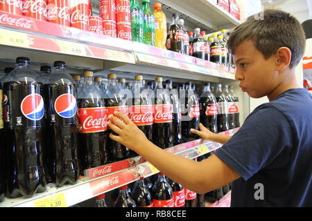 11-jähriger Junge Kauf alkoholfreie Getränke im Salento, Italien. Stockfoto