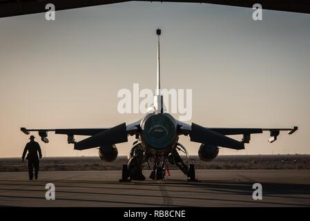 Eine Crew Chief mit dem 407 Expeditionary Aircraft Maintenance Squadron Wanderungen vorbei an einem F-16 Fighting Falcon, die 134 Expeditionary Fighter Squadron am 407 Air Expeditionary Gruppe, Vorderasien, Dez. 10, 2016 zugeordnet. Über 300 Piloten aus dem 158 Fighter Wing der Vermont Air National Guard umfassen die Einheiten. Stockfoto