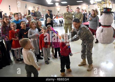 Us Armee Sgt. 1. Klasse Ana Doody, 316 Psychologische Operationen Firmentraining noncommissioned Officer zuständig, verwaltet die Kinder versuchen, eine piñata während ihrer jährlichen Tag der Familie in Kokomo, Ind., 10.12.2016, Streik. Während der Veranstaltung Kinder hatten auch Gelegenheit, Santa zu besuchen und Geschenke in Empfang nehmen. Stockfoto