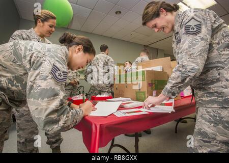 Tech. Sgt. Jane Hunter, Links, 177Th Communications Flug und Master Sgt. Jamie Nieves, rechts, Bauingenieur 177th Squadron, sowohl mit den New Jersey Air National Guard, Karten für die Bewohner bei der New Jersey Veterans Memorial Home in Vineland, N. J., Dez. 13, 2016. Mehr als 80 Viertklässler aus der Seaview Volksschule in Linwood, N. J., verband die 18 Flieger urlaub Lieder zu singen und ausgeteilten Karten zu den Bewohnern des Haus während des 16. jährlichen Urlaub ongfest" auf der Startseite. Stockfoto