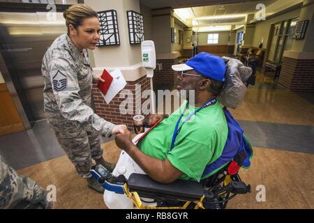 Master Sgt. Jamie Ludy, Links, 177Th Maintenance Squadron, bietet Air Force Vietnam Veteran Ed Taylor eine Karte in der 16. jährlichen Urlaub ongfest' an der New Jersey Veterans Memorial Home in Vineland, N. J., Dez. 13, 2016. Mehr als 80 Viertklässler aus der Seaview Volksschule in Linwood, N.J., und 18 Flieger sang holiday Songs und ausgeteilten Karten zu den Bewohnern des Hauses während der Veranstaltung. Stockfoto