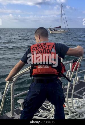 Coast Guard Besatzungsmitglieder an Bord eines 45-Fuß-Antwort Boat-Medium (RMB) vom Bahnhof Fort Myers Beach Rettung drei Nautiker und Entwässern ein 35-Fuß-Segelboot Freitag, Dezember 16, 2016, 12 Meilen westlich von Sanibel Island, Florida. Stockfoto