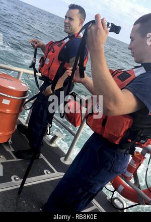 Coast Guard Besatzungsmitglieder an Bord eines 45-Fuß-Antwort Boat-Medium (RBM) vom Bahnhof Fort Myers Beach bereiten Sie ein 35-Fuß-Segelboot zu entwässern nach Rettung drei Segler Freitag, Dezember 16, 2016, 12 Meilen westlich von Sanibel Island, Florida. Stockfoto