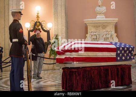 Ein Mann begrüßt, den Sarg von Senator John Glenn, jr., während ein Public Viewing am Ohio Statehouse, Columbus, Ohio, am 16. Dezember 2016. In 149 Einsätze im Zweiten Weltkrieg und im Koreakrieg, Glenn wurde der erste Amerikaner im Orbit 1962 geflogen. Nach seinem Ausscheiden aus dem Raumfahrtprogramm, Glenn war der US-Senat 1974 gewählt Der Zustand von Ohio zu vertreten. Stockfoto