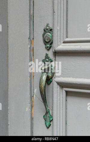 Im Alter von Türklinke in Cooper auf einer grauen Tür Hintergrund. Vertikale Ansicht, close-up Stockfoto