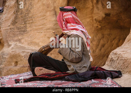 Alten Beduinen in der kufiya spielt auf der nationalen Musikinstrument von Jordanien, Petra, Jordanien Stockfoto