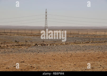 Hohe Spannung elektrische Stromleitungen als Teil des Stromnetzes im roten Sand der Wüste, Jordanien Stockfoto