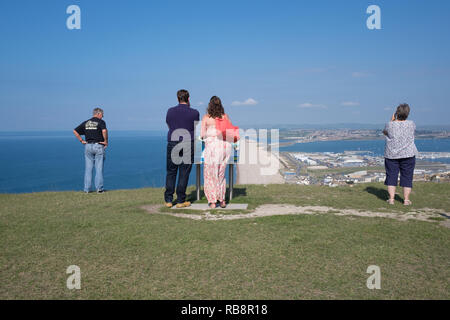 Vier Personen mit Blick auf die Weymouth Bay aus Portland an. Stockfoto