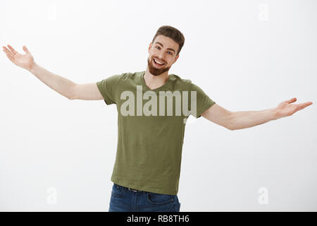 Mate lange Zeit nicht sehen, mich umarmen. Portrait von überrascht und Glücklich, aufgeregt, gut aussehenden Kaukasier Männlich mit Bart lächelt freundlich mit uns Ausdruck stretch Hände in Empfang und Begrüßung Stockfoto