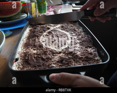 Haus Frau Schneid- und Vorbereitung von Tiramisu. Stockfoto