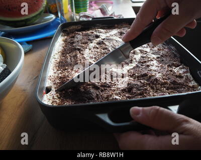 Haus Frau Schneid- und Vorbereitung von Tiramisu. Stockfoto