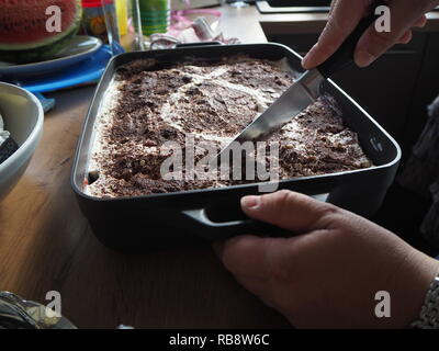 Haus Frau Schneid- und Vorbereitung von Tiramisu. Stockfoto