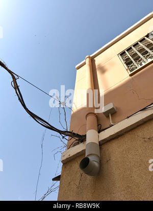 Sonne scheint die elektrischen Kabel, Anschluss an der Außenseite der Wand des Hauses Stockfoto