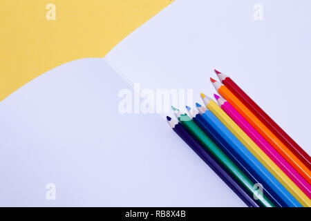 Nahtlose farbigen Regenbogen Buntstifte auf Blatt weißes Papier Schule Zeichnung album auf gelben Hintergrund. Konzept der freien Raum, Copyspace, Cov Stockfoto