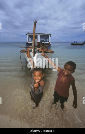 Lokalen Dorf Familie entladen Holz von einem Boot aus, Yaqeta Island. Yasawa Islands, Fidschi. South Pacific Stockfoto