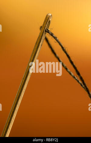 Makroaufnahme der Nadel mit Auge schwarzen Faden. Nahaufnahme Stockfoto