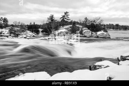 Ein schwarz-weiß Bild von Burleigh fällt im Winter, wie das kalte Wasser purzelt unten über den Felsen in eine Unschärfe von Buckhorn See Stoney See. Stockfoto