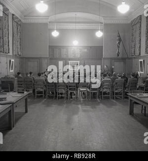 1950, historische, Student, ein Abend Rede zu erwachsenen Dozenten und Professoren und Studenten sitzen zusammen in einem Holzgetäfelten rom, Oxford University, England, Großbritannien