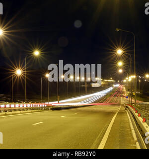 Traffic bei dramatischen Sonnenuntergang Zeit - leichte Wanderwege auf der Autobahn Autobahn bei Nacht, Langzeitbelichtung Abstract im städtischen Hintergrund Stockfoto