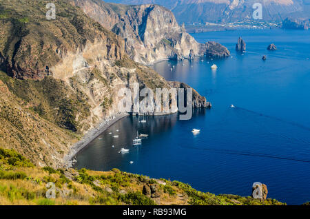 Atemberaubende Aussicht auf das Valle Muria Strand in Lipari und die Faraglioni. Im Hintergrund der Krater von Vulcano Insel. Äolische Inseln, Sizilien Stockfoto